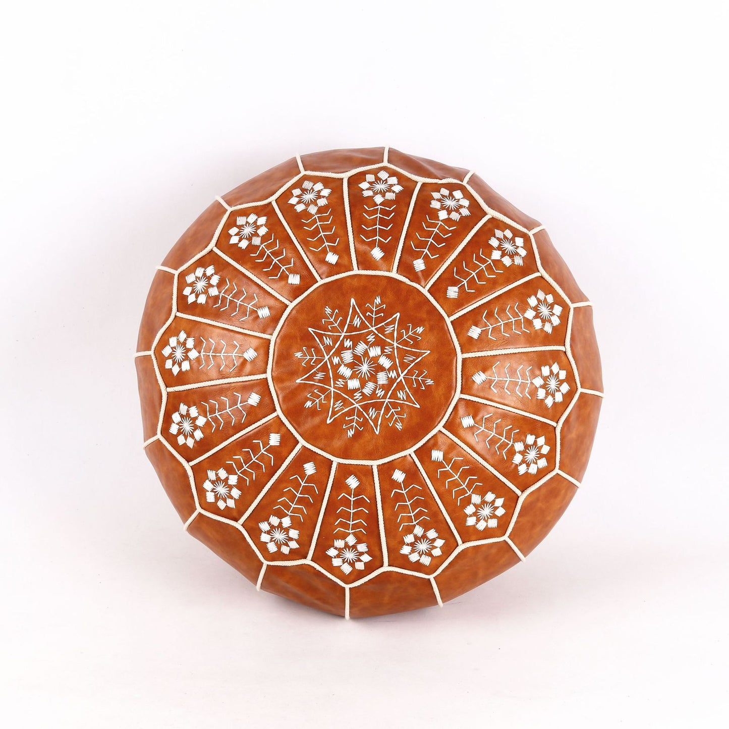 "Coussin diamètre 55 cm en cuir naturel - Comparaison taille avec livre/mains pour échelle"